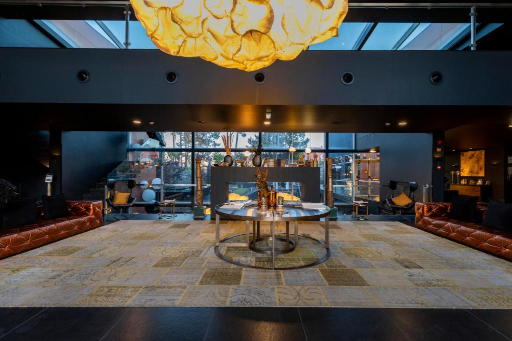 a large room with a table and a large chandelier at Evidencia Belverde Hotel in Amora
