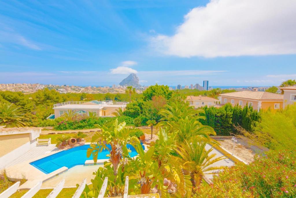 an aerial view of a villa with a swimming pool and palm trees at Villas Guzman - Ifach in Calpe