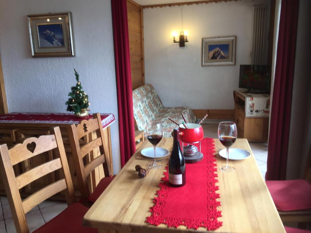 - une table avec deux verres à vin et un sapin de Noël dans l'établissement Chamonix Centre Holiday Sauna Apartment 2, à Chamonix-Mont-Blanc