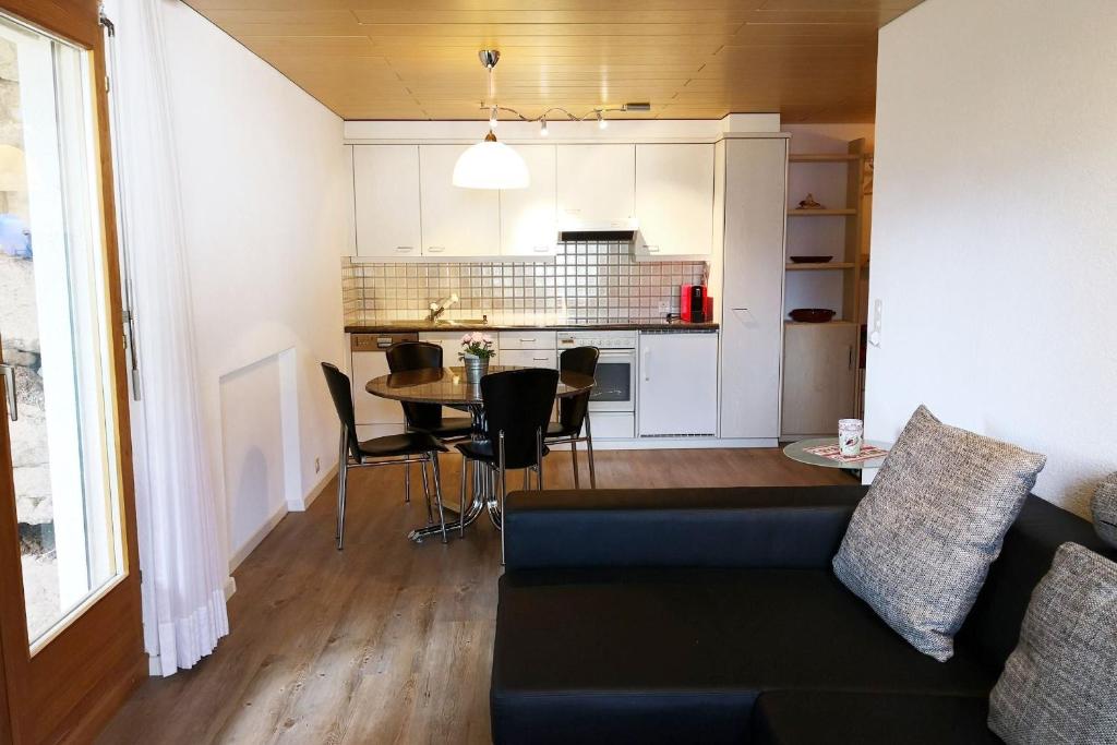 uma sala de estar e cozinha com um sofá e uma mesa em Haus zur Tanne - CharmingStay em Flumserberg
