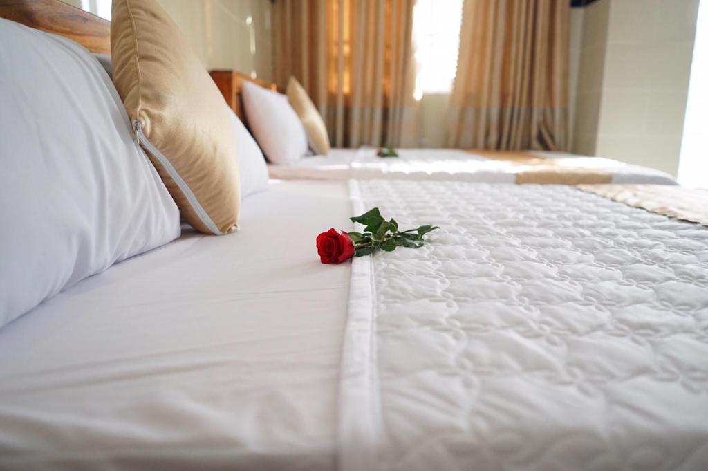a red rose sitting on top of a white bed at Hotel Hoai Anh in Vung Tau