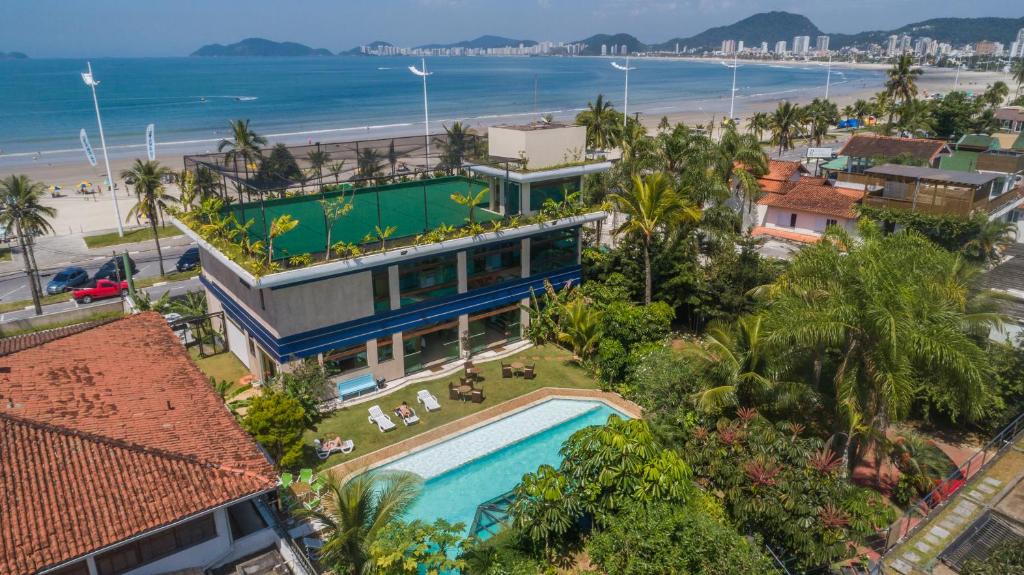 uma vista aérea de uma casa com piscina e praia em Pousada Stand Up! Guarujá no Guarujá