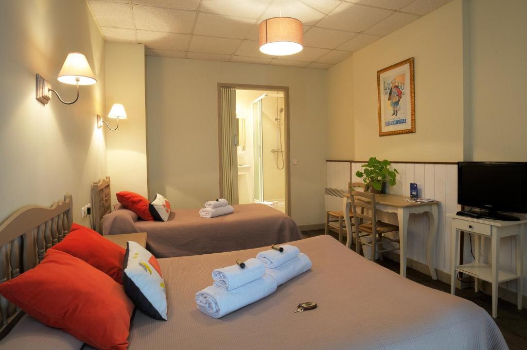 um quarto de hotel com duas camas e uma televisão em Au Fin Gourmet em Le Croisic