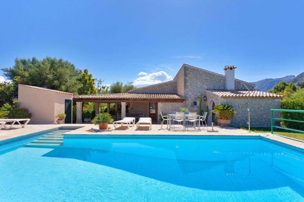 a swimming pool in front of a house at Can Venzala in Pollença