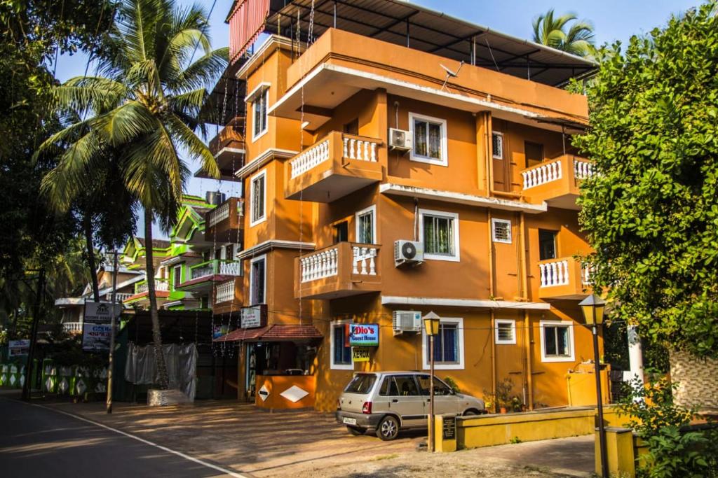 a yellow building with a car parked in front of it at Dio's Guest House in Utorda