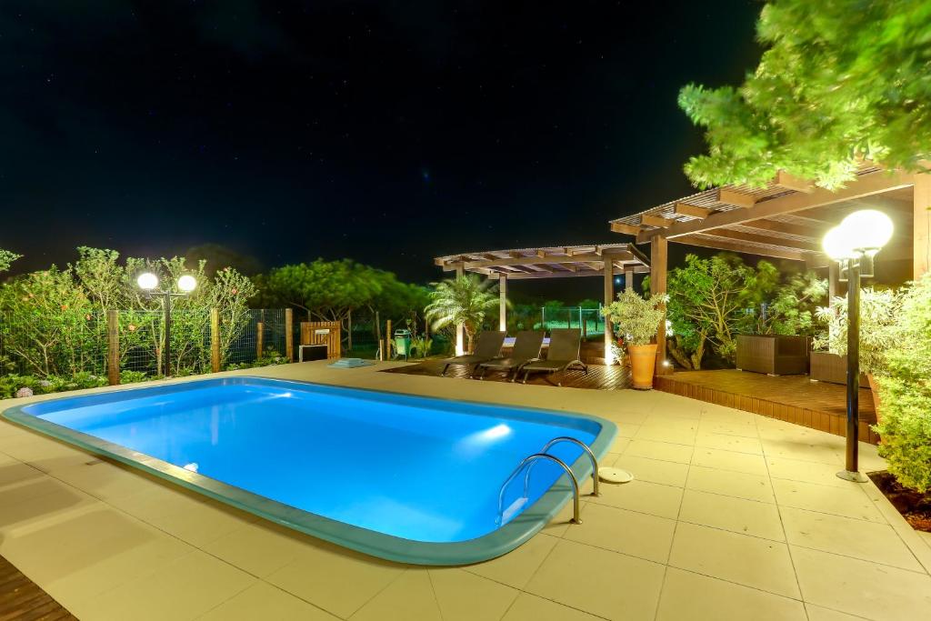 a swimming pool in a backyard at night at Pousada Ilha Faceira in Florianópolis