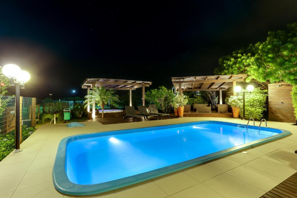 a swimming pool in a backyard at night at Pousada Ilha Faceira in Florianópolis