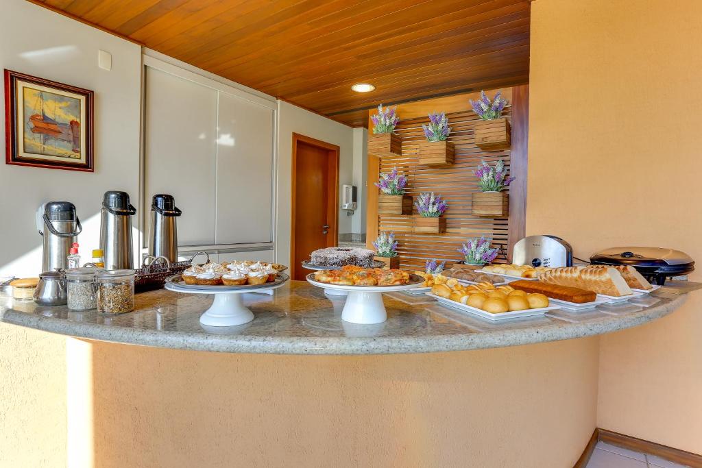 a counter with several plates of food on it at Pousada Ilha Faceira in Florianópolis