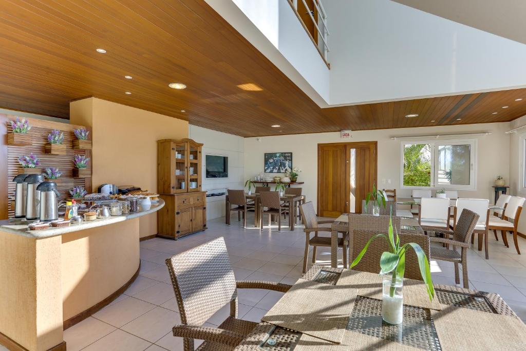 a kitchen and dining room with tables and chairs at Pousada Ilha Faceira in Florianópolis
