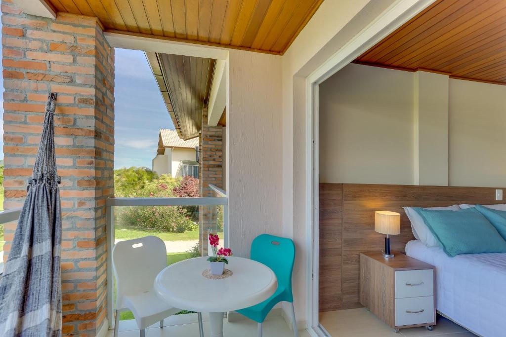 a bedroom with a bed and a table and chairs at Pousada Ilha Faceira in Florianópolis