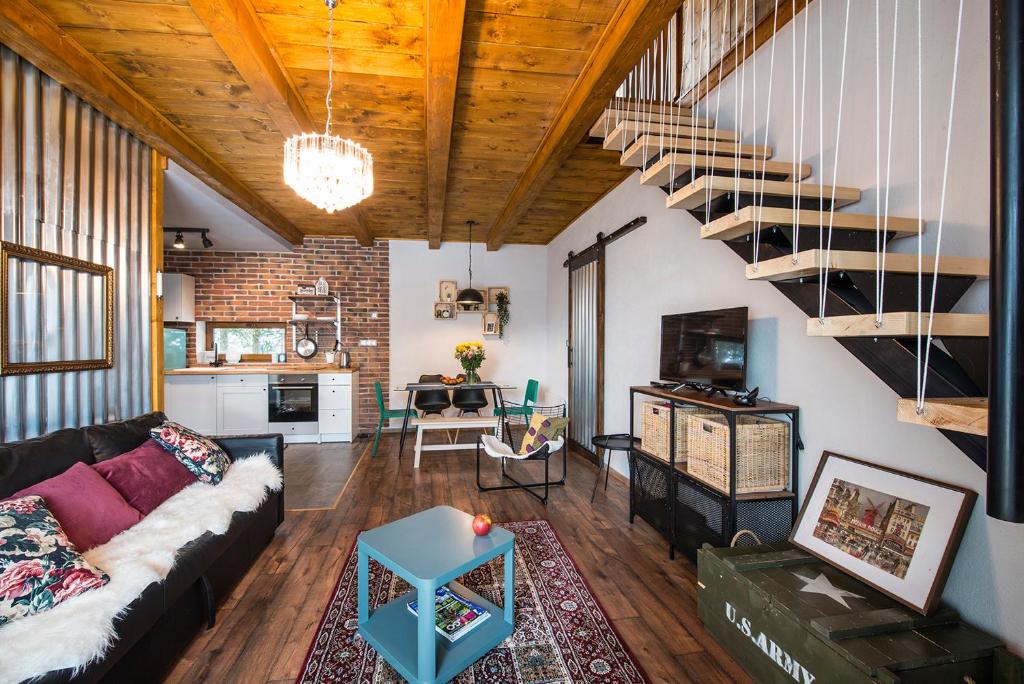 a living room with a couch and a staircase at Apartmany Calma in Liptovský Mikuláš