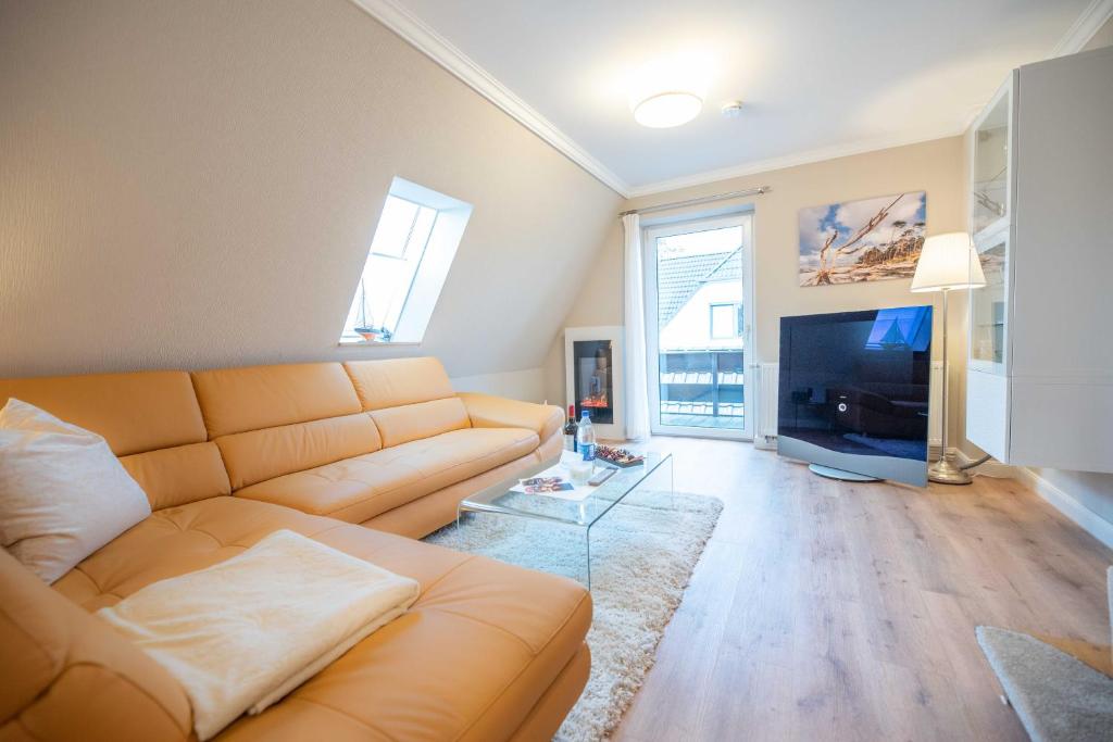 a living room with a couch and a tv at Ferienwohnungen Hofmann in Zingst