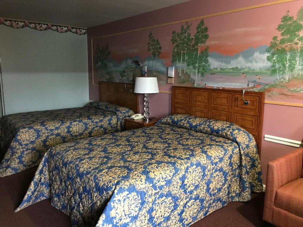 una habitación de hotel con 2 camas y una silla en Village Inn en Lovingston