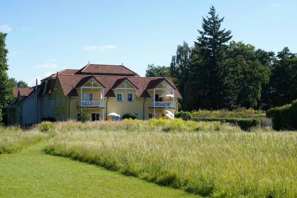 a large yellow house with a field of grass at Ferien in Himmelpfort in Himmelpfort