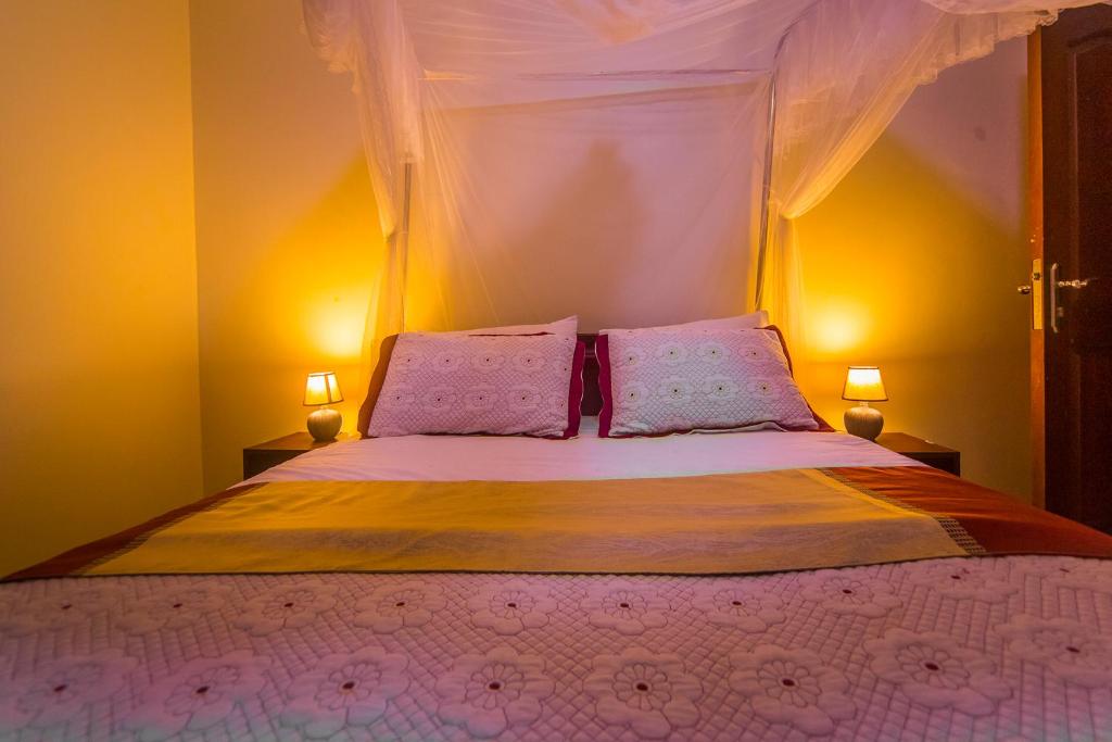 Hotel Royal Nest Entebbe tesisinde bir odada yatak veya yataklar