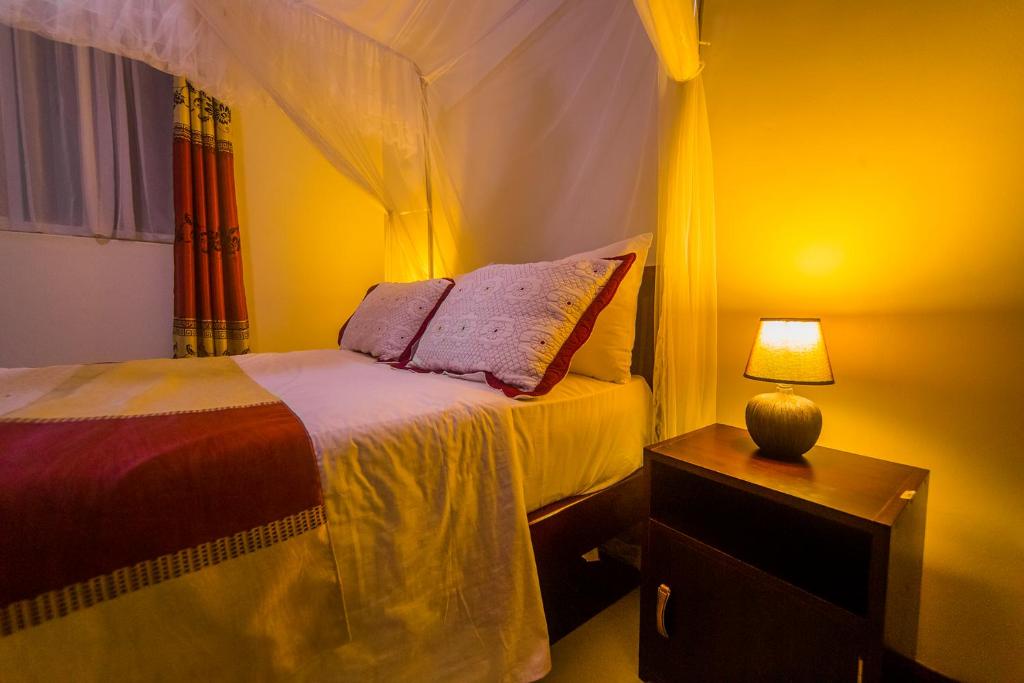 Hotel Royal Nest Entebbe tesisinde bir odada yatak veya yataklar