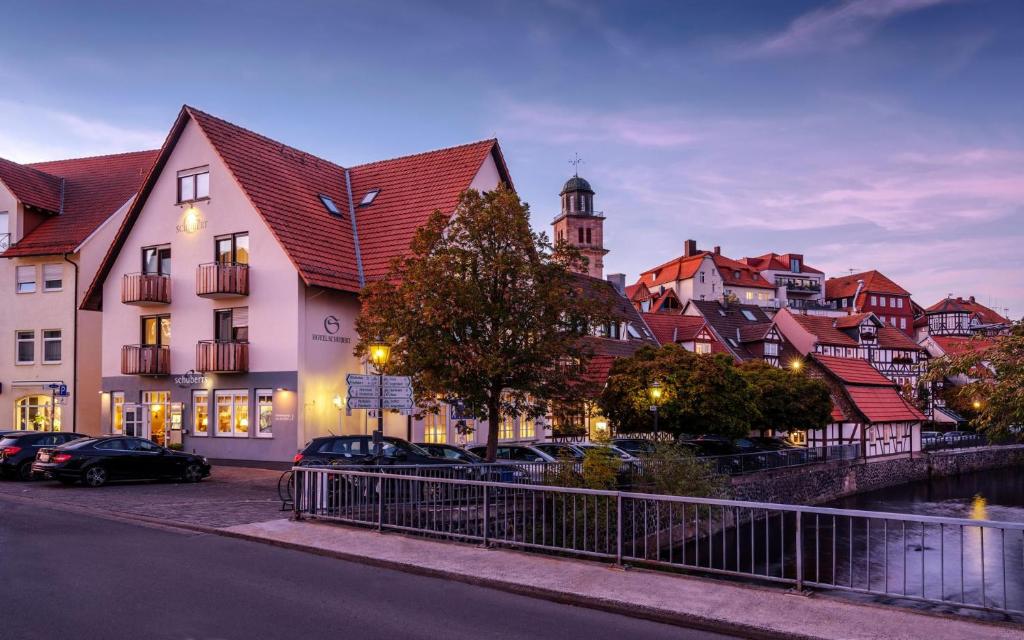 eine Stadt mit Autos, die vor einem Gebäude geparkt sind in der Unterkunft Romantik Hotel Schubert in Lauterbach