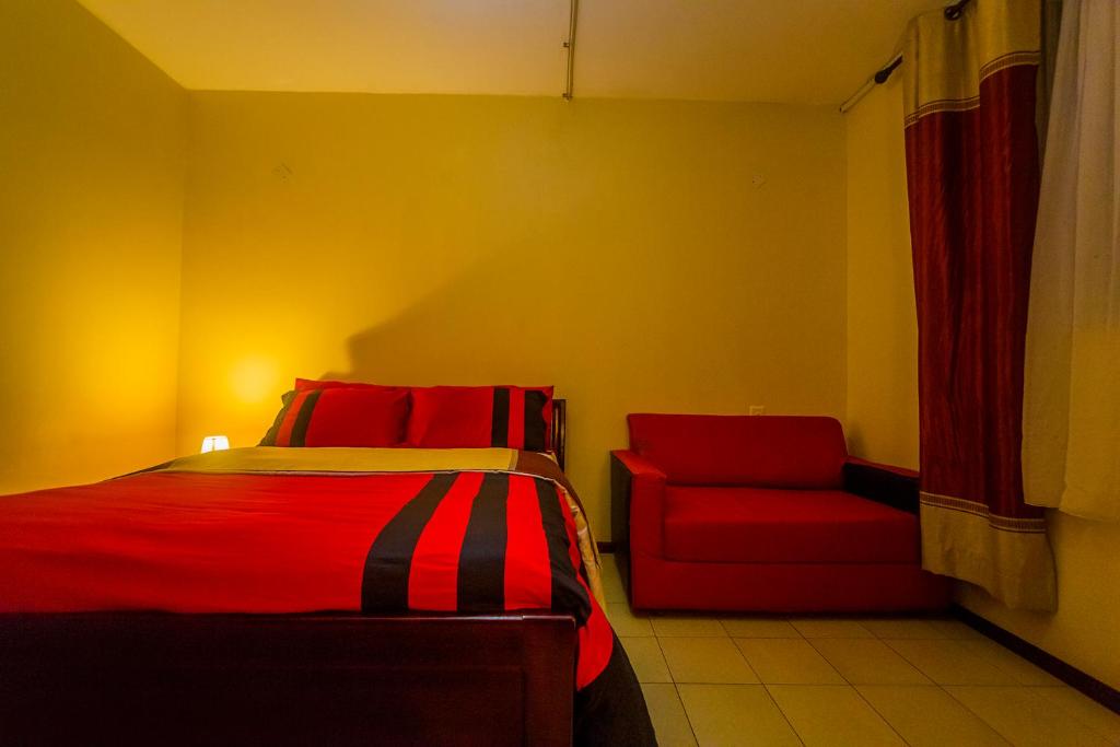 Hotel Royal Nest Entebbe tesisinde bir odada yatak veya yataklar
