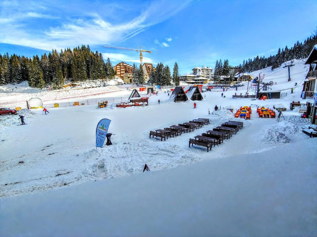 eine schneebedeckte Skipiste mit Stühlen im Schnee in der Unterkunft Apartmani Stelo Jahorina in Jahorina