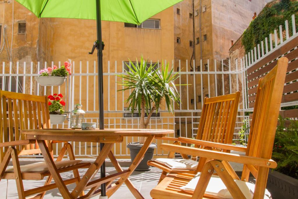 una mesa y sillas con una sombrilla en el patio en Central Terrace Modern Apartment, en Tesalónica