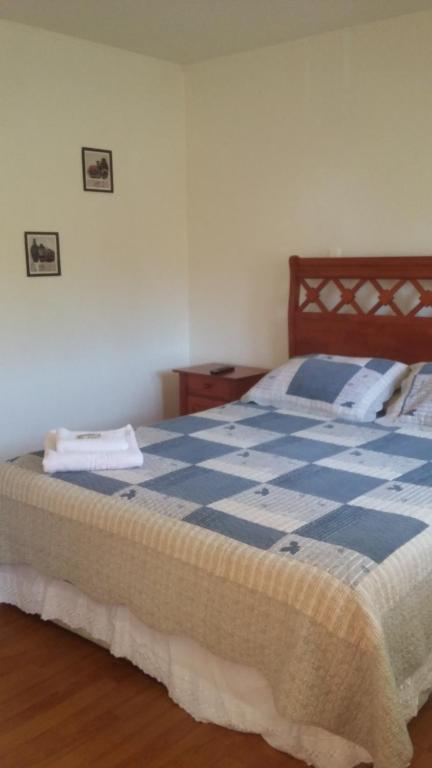 a blue and white bed in a room at Hotel Nogal in Constitución