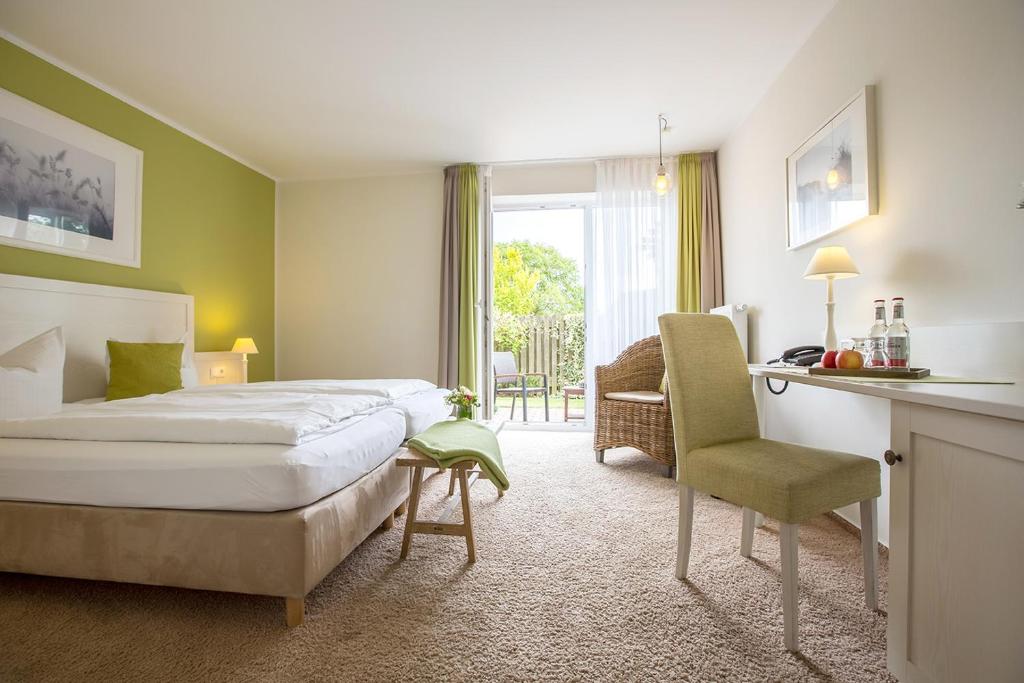 Pokój hotelowy z łóżkiem, biurkiem i krzesłem w obiekcie Paulsen's Landhotel und Restaurant w mieście Bohmstedt