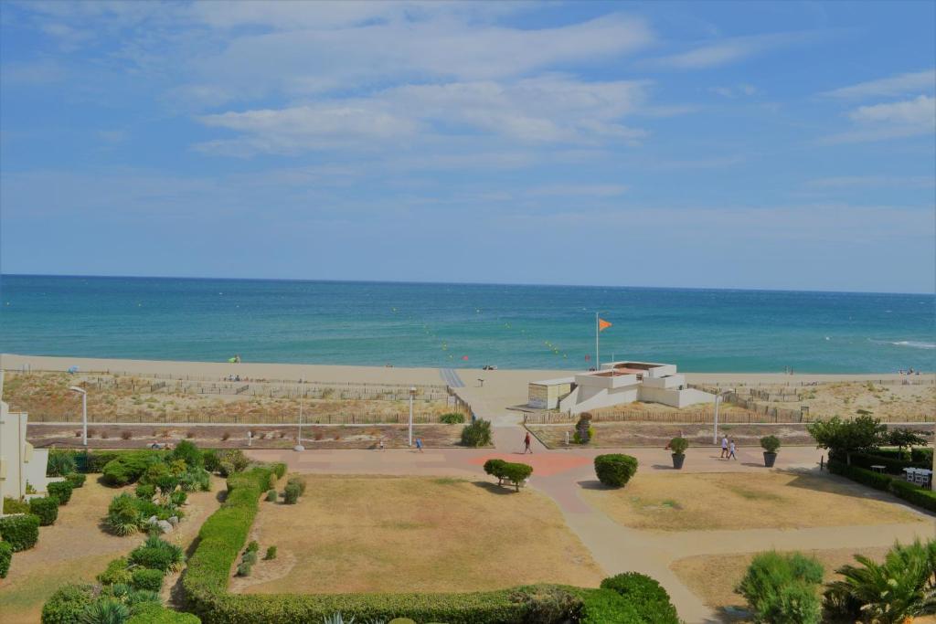 Blick auf einen Park mit Strand im Hintergrund in der Unterkunft Studio Lovely Sea in Le Barcarès