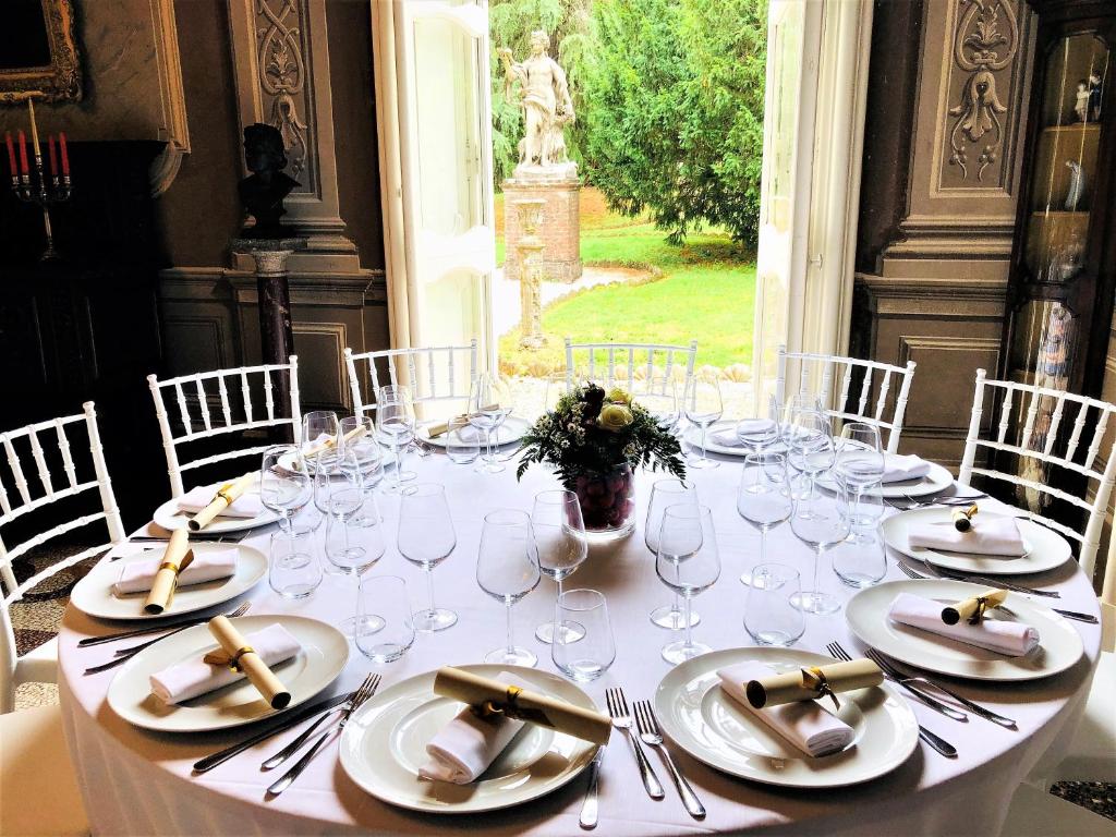 ノーヴィ・リーグレにあるVilla Capanninaの白皿とワイングラスが付いたテーブル