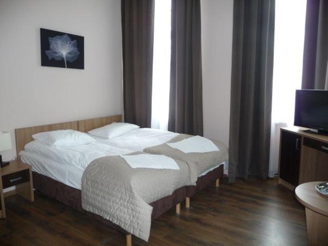 a hotel room with a bed and a television at Victoria in Międzyzdroje