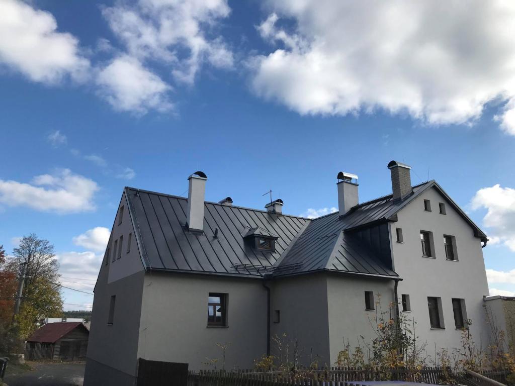 a white house with a black roof at Apartmány Michaela in Abertamy