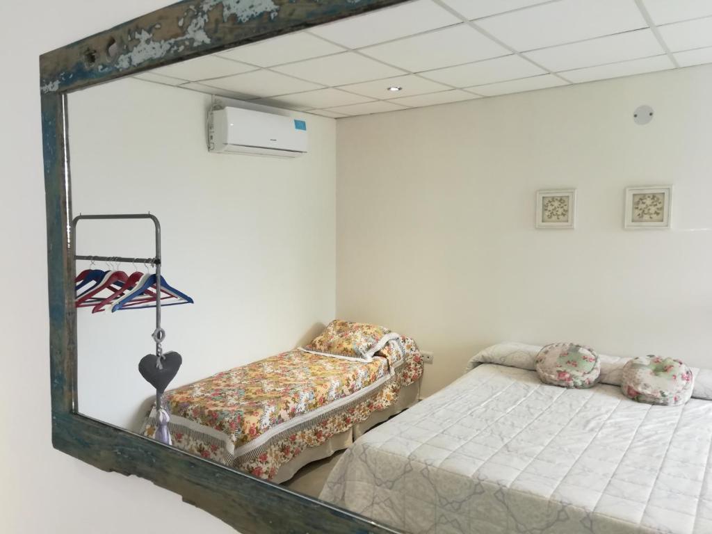 einen Spiegel in einem Zimmer mit einem Bett und einem Stuhl in der Unterkunft EFE Aparts in Mina Clavero