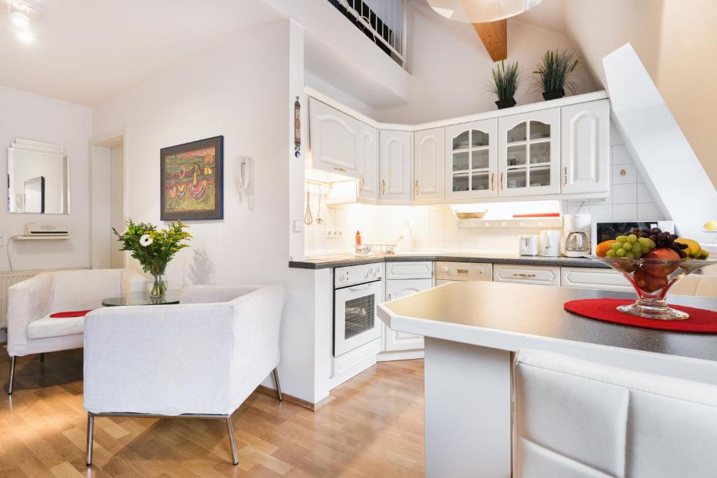 a kitchen with white cabinets and a table and chairs at Comeback Apartment Central in Dresden