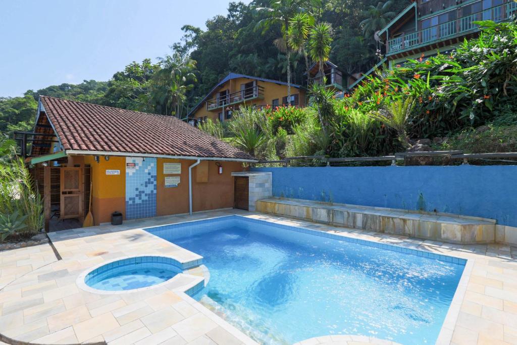 una piscina davanti a una casa di Waldhaus - A Pousada do Remo a Peruíbe