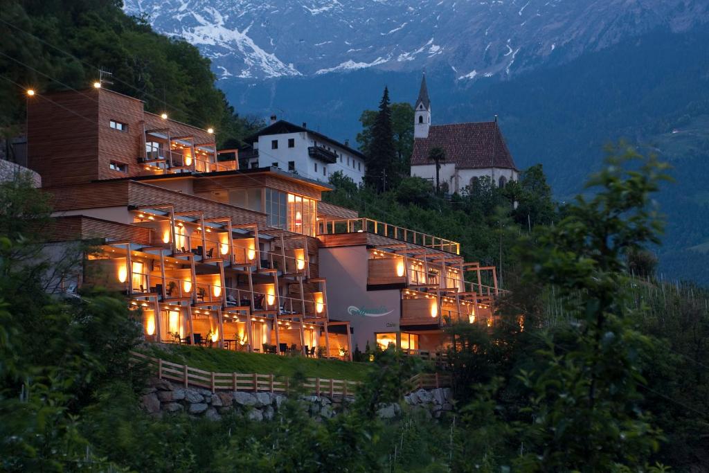 a large building on the side of a hill at night at Residence Aqualis in Marlengo