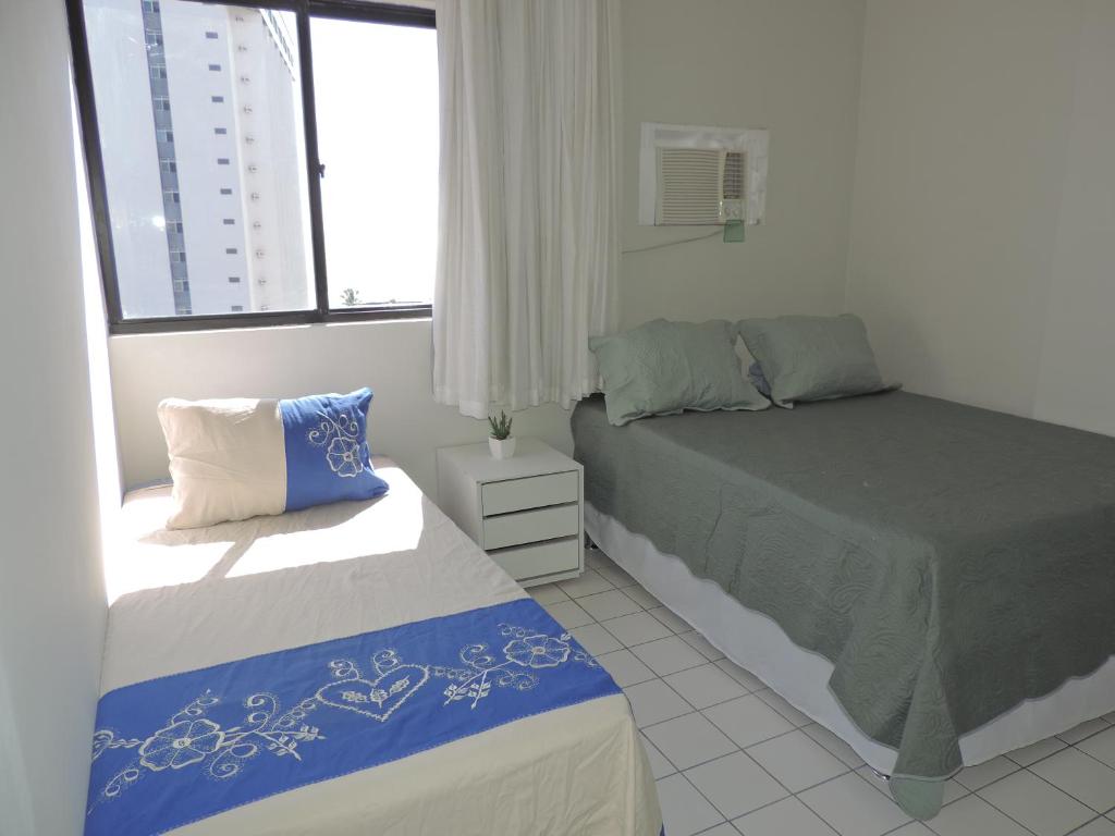 1 dormitorio con 2 camas y ventana en Flat Pina/Boa Viagem, en Recife