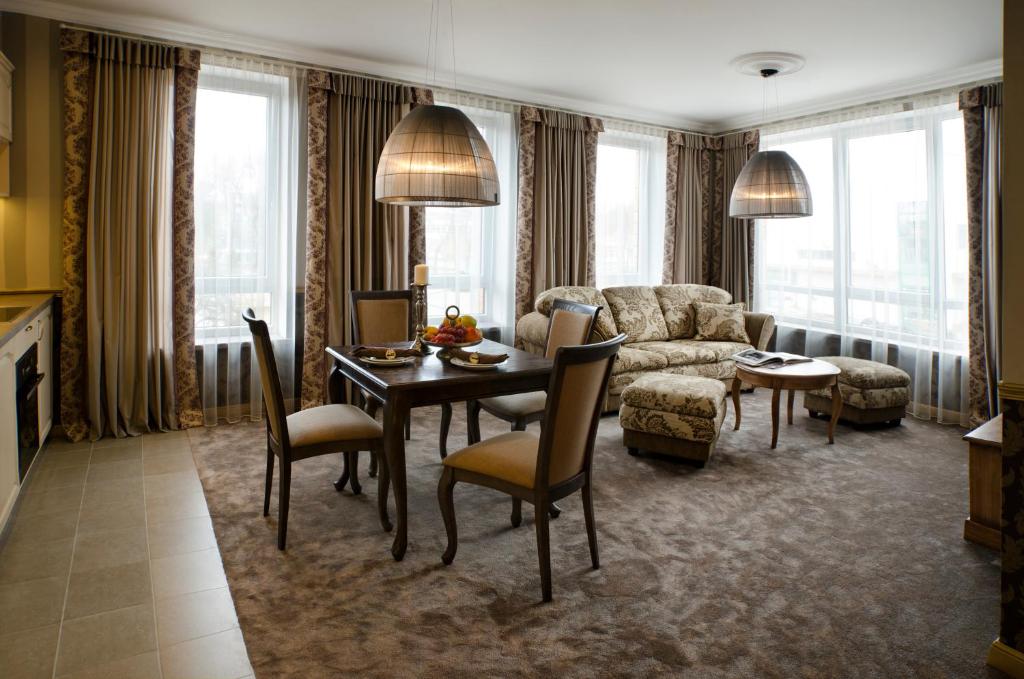 un soggiorno con tavolo e divano di Ursula Royal Apartments a Druskininkai