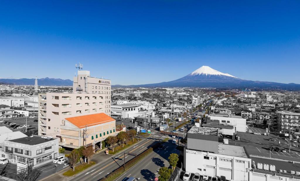 a view of a city with a mountain in the background at APA Hotel Fujichuo in Fuji