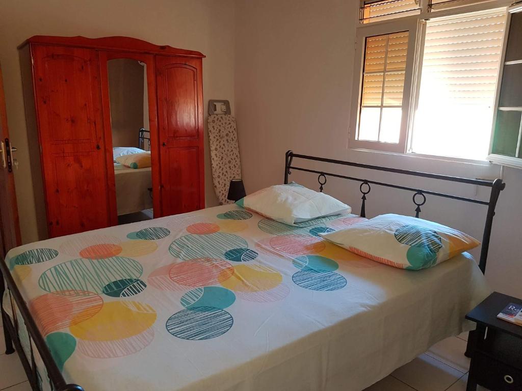 a bedroom with a bed with a flower pattern on it at chez jojo in Baie-Mahault