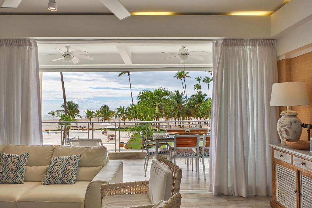 a living room with a couch and a view of the ocean at Juan Dolio Costa del Sol in Juan Dolio
