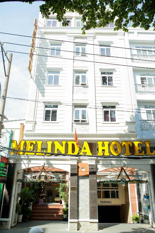 um hotel em frente a um edifício branco em Melinda Hotel em Cidade de Ho Chi Minh