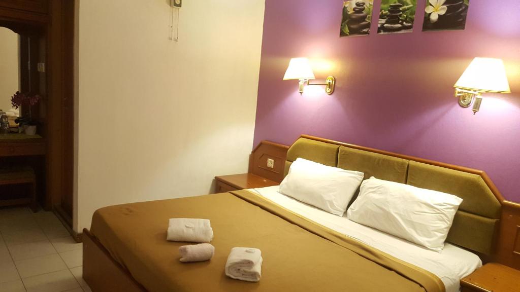 Postel nebo postele na pokoji v ubytování New Orchid Hotel Tuaran
