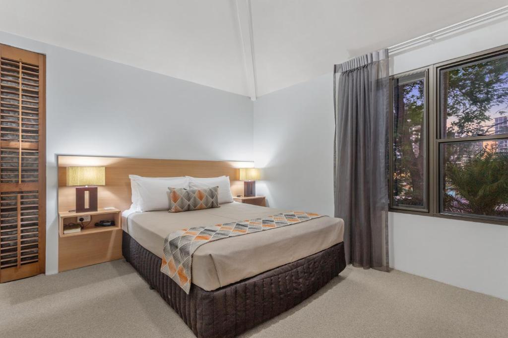 een slaapkamer met een groot bed en een raam bij Airport International Motel Brisbane in Brisbane