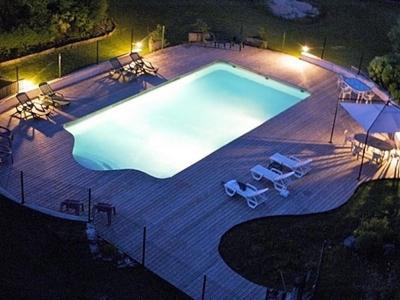 an empty swimming pool at night with lights at Hôtel Restaurant des Lacs in Chaux-des-Crotenay