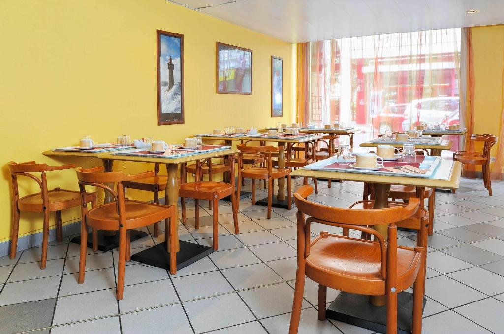ein Restaurant-Esszimmer mit Tischen und Stühlen in der Unterkunft Séjours &amp; Affaires Lyon Saxe-Gambetta in Lyon