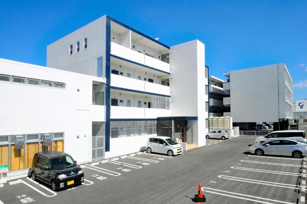 a parking lot with cars parked in front of a building at Costa Bella Condominium Resort in Motobu