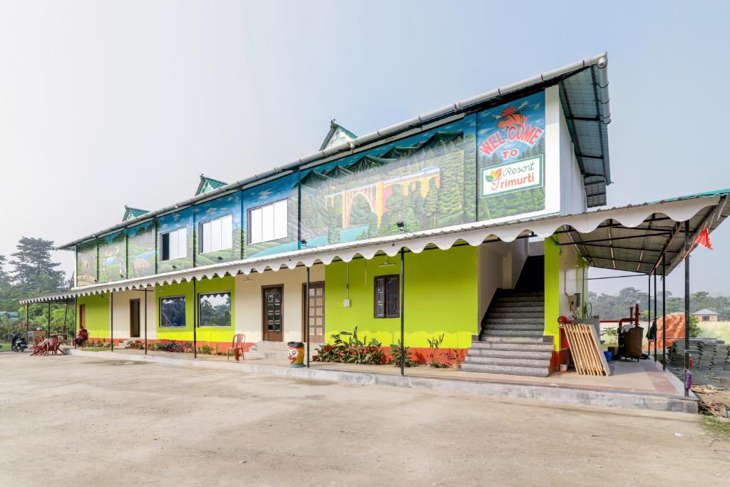 a building with a green and yellow building at Resort Trimurti in Chālsa Mahābāri