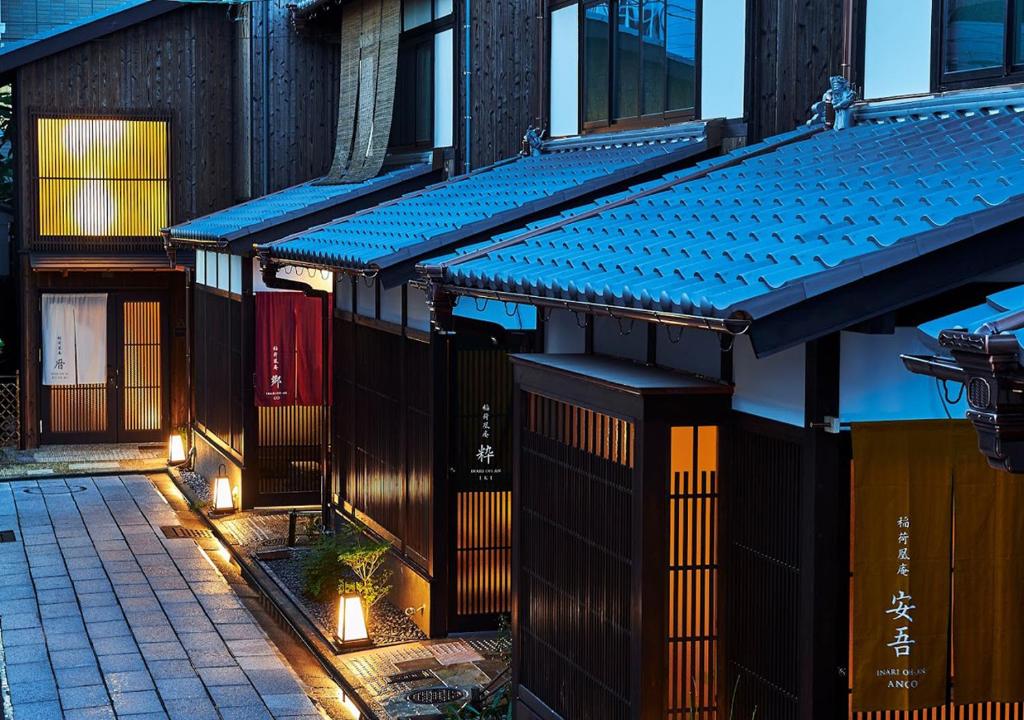 a building with a blue awning next to a street at Inari Ohan in Kyoto