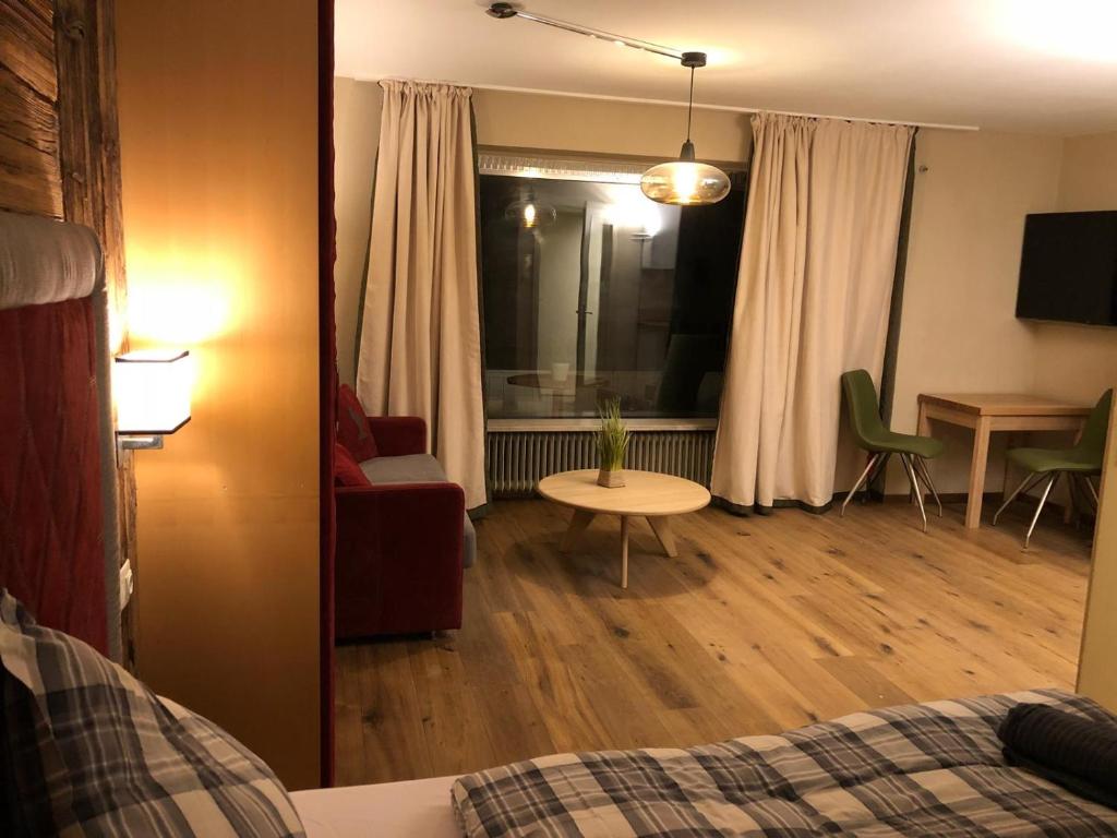 Pokój z łóżkiem i stołem oraz salonem w obiekcie Kitzbühel City 1 w mieście Kitzbühel