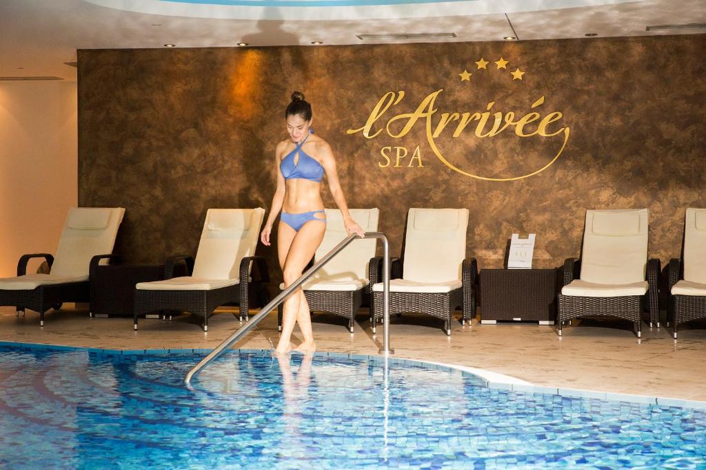Eine Frau im Bikini steht im Pool in der Unterkunft l'Arrivée Hotel & Spa in Dortmund