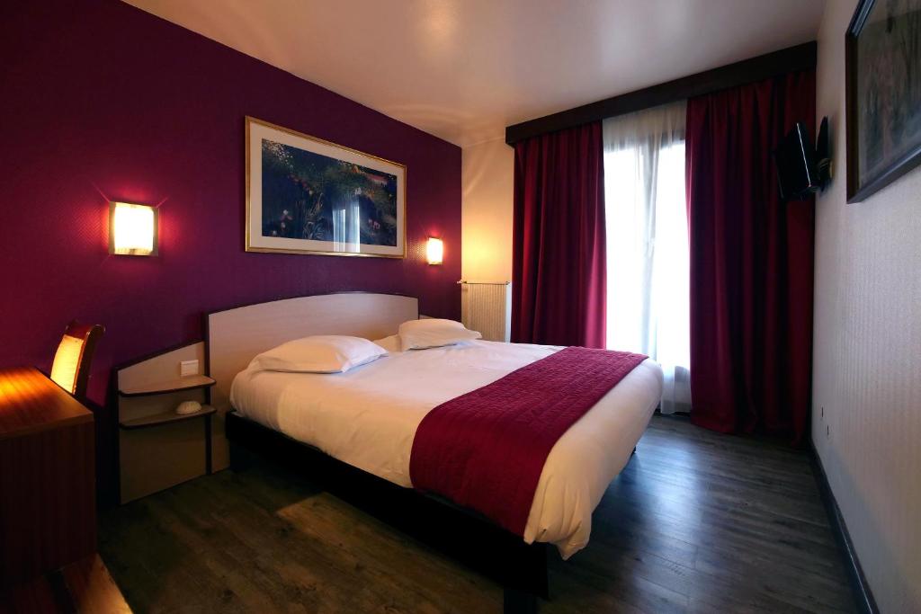 Schlafzimmer mit einem großen Bett mit roten Wänden in der Unterkunft Le Vert Galant in Villepinte